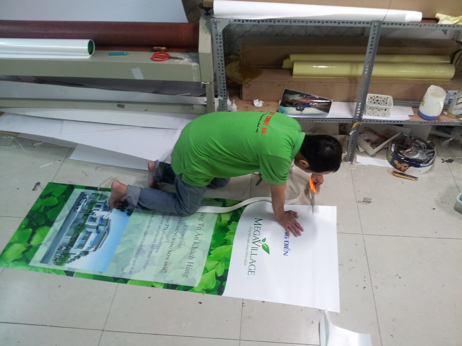 Nhân viên CongTyInNhanh đang gia công thành phẩm poster banner PP cho khách hàng